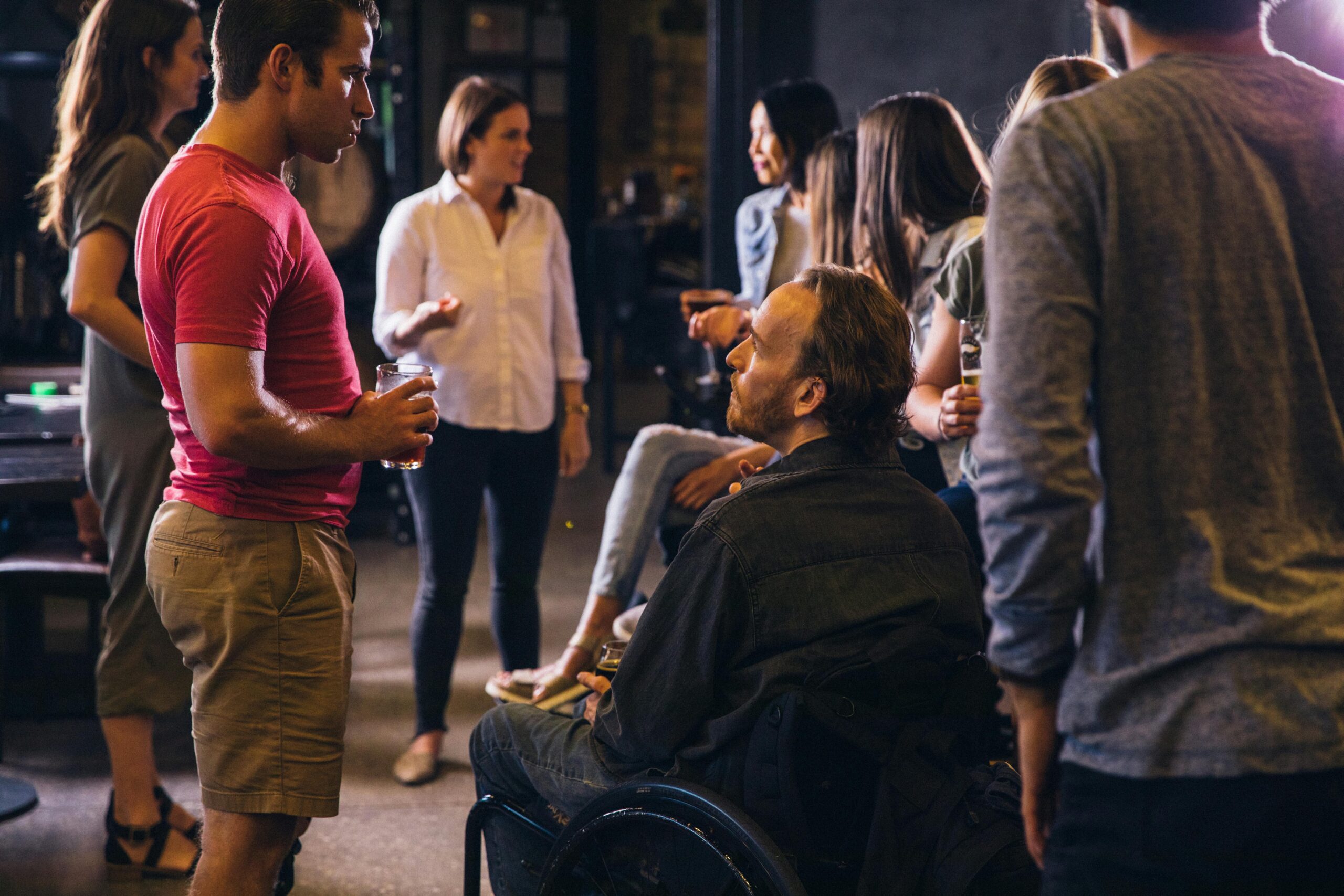 A caring staff member assisting an NDIS participant during a community activity.